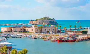 Piękna pogoda w Kusadasi w październiku. Słoneczny dzień nad zatoką pełną łodzi, z widokiem na zamek na wyspie.