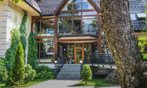 Elegancki hotel Belvedere Resort & Spa z imponującą szklaną fasadą i zielenią wokół.