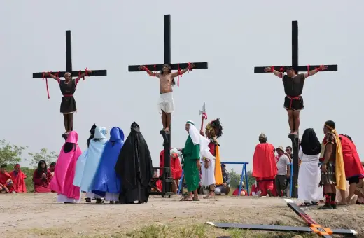 Filipiny religia: inscenizacja ukrzyżowania Jezusa z udziałem wiernych w barwnych strojach.