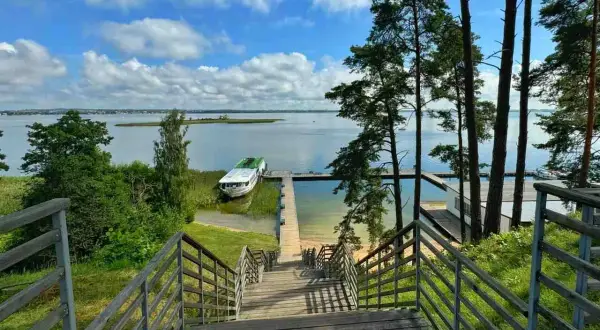 Schody prowadzą do jeziora, gdzie cumuje statek. Idealne miejsce, by zapytać: gdzie na Mazury?