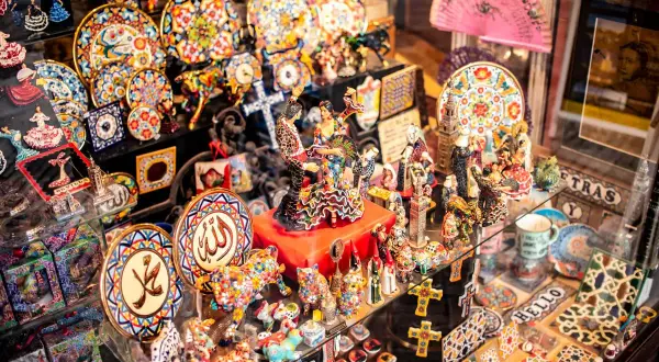 Kolorowe pamiątki z Hiszpanii: talerzyki, figurki tancerzy flamenco, wachlarze, mozaikowe zwierzęta. Idealne, by pomyśleć, co przywieźć z Hiszpanii.