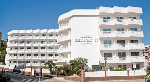 Hotel Bernat II, idealny na wakacje all inclusive w Barcelonie. Biały budynek z balkonami i widokiem na morze.