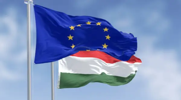 Flaga UE i Węgier powiewają na wietrze. Czy na Węgrzech można płacić euro? Oficjalnie nie, ale Unia Europejska to symbol wspólnoty.