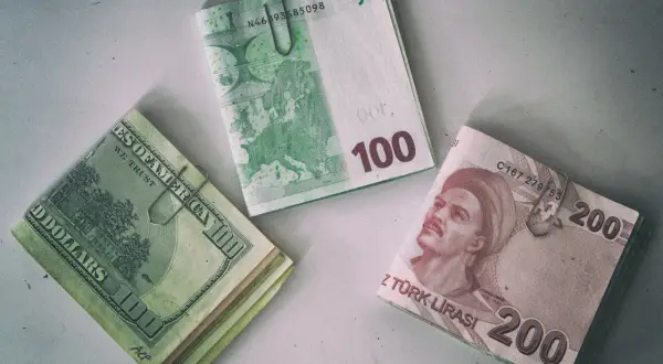 Stos banknotów 200 lir tureckich obok dolarów i euro. W Turcji można płacić lirami, ale też często akceptowane są dolary i euro.