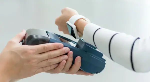 Płatność zbliżeniowa zegarkiem w sklepie we Włoszech. Nowoczesna waluta euro płynie przez technologię.