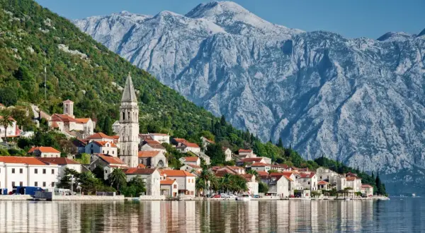 Perast w Czarnogórze, kwiecień. Słoneczna pogoda, spokojne morze odbija malownicze domy i góry.