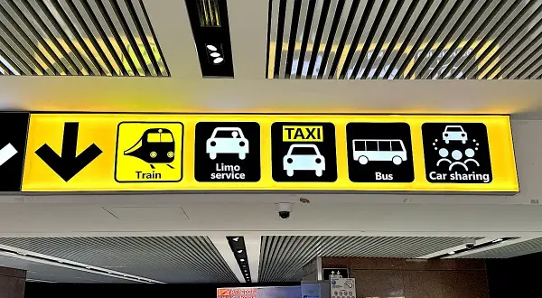Znaki transportu na lotnisku Rzym Fiumicino: pociąg, limuzyna, taksówka, autobus, car sharing.