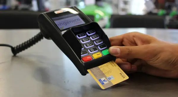 Złota karta płatnicza VR-BankCard Plus w terminalu płatniczym. W Niemczech płatności kartą są powszechne, a ta karta to przykład waluty w niemczech.
