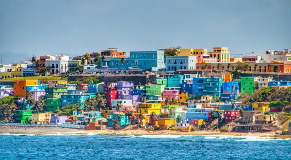Kolorowe domy na wzgórzu nad oceanem, typowe dla krajobrazu Puerto Rico, gdzie jest to miejsce pełne słońca i barw.
