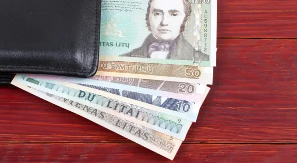Czarny portfel z litewskimi banknotami. Widać banknot 100 litów z portretem mężczyzny, a pod nim mniejsze nominały: 50, 20, 10, 5 litów. Litwa waluta.