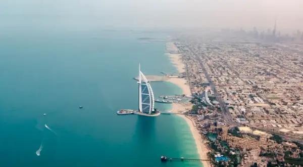 Widok z lotu ptaka na luksusowy hotel Jumeirah w Dubaju, z turkusową wodą i piaszczystą plażą.