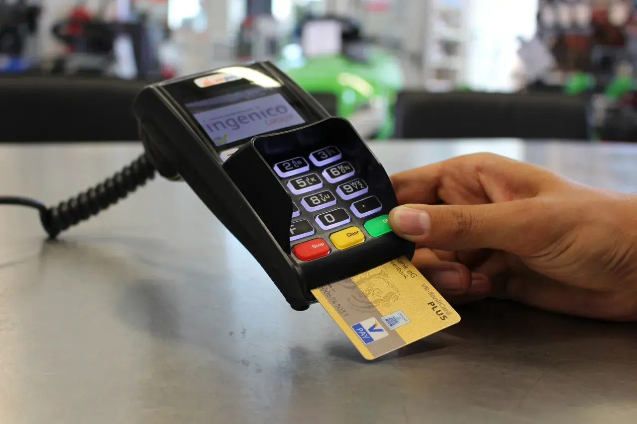 Złota karta płatnicza VR-BankCard Plus w terminalu płatniczym. W Niemczech płatności kartą są powszechne, a ta karta to przykład waluty w niemczech.