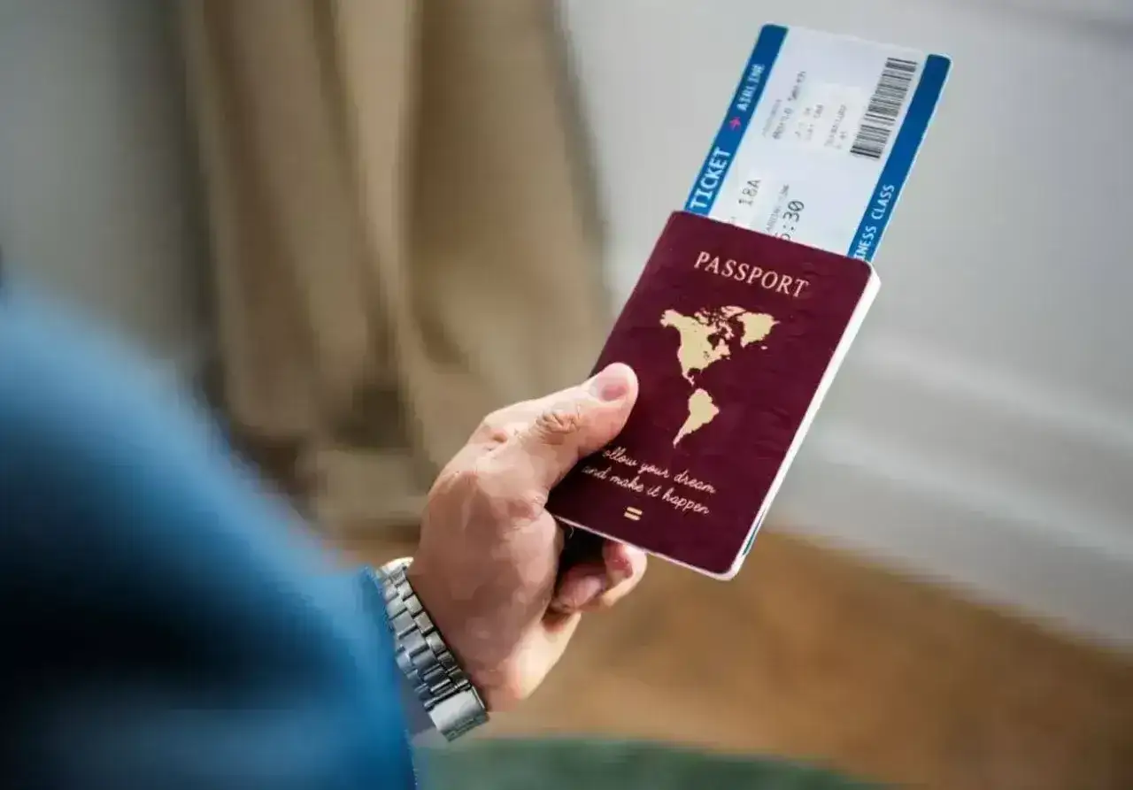 Dłoń trzyma paszport i bilet lotniczy. Czy Cypr jest w Schengen? Podróż marzeń czeka!