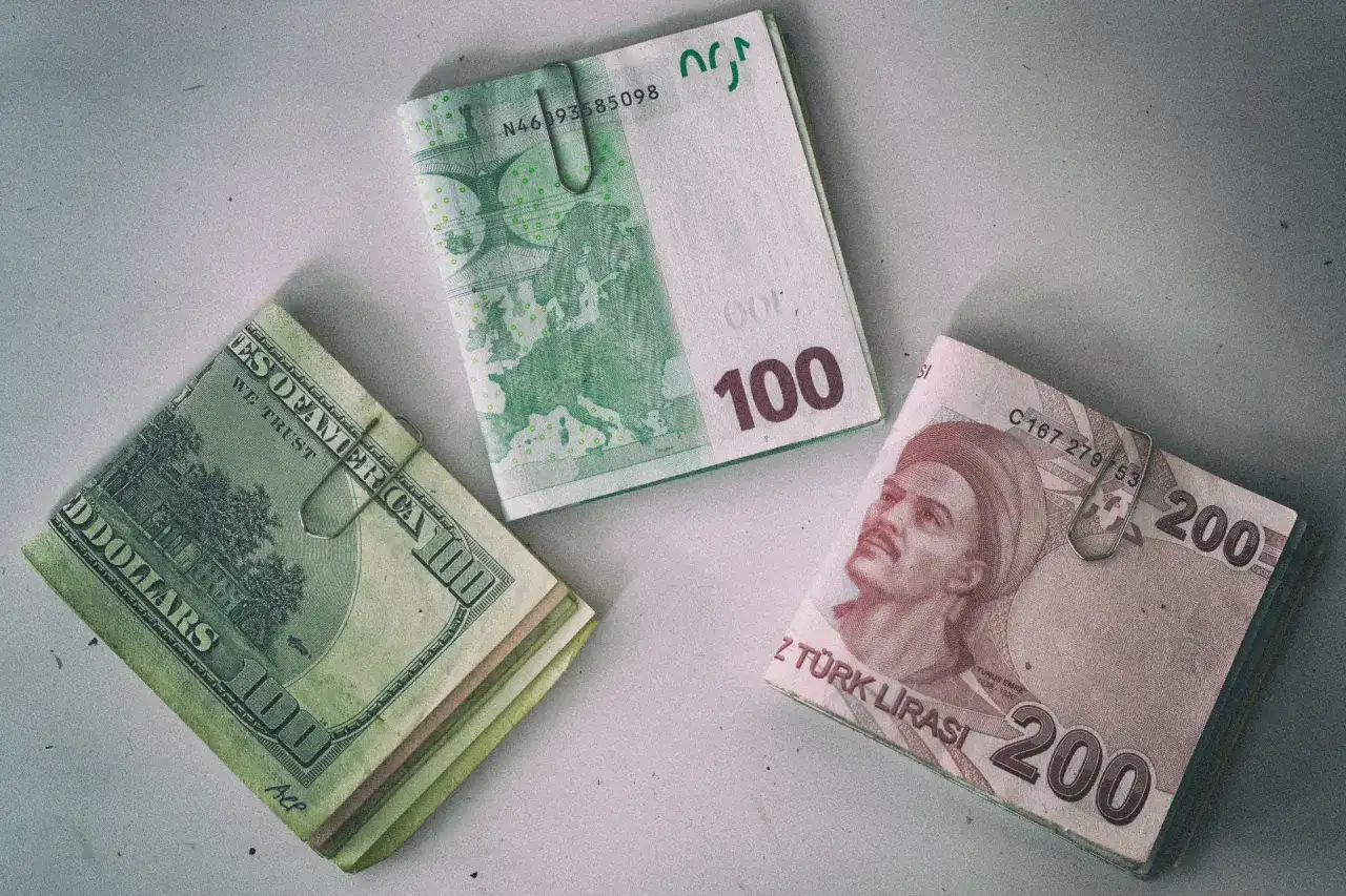 Stos banknotów 200 lir tureckich obok dolarów i euro. W Turcji można płacić lirami, ale dolary i euro też są akceptowane.